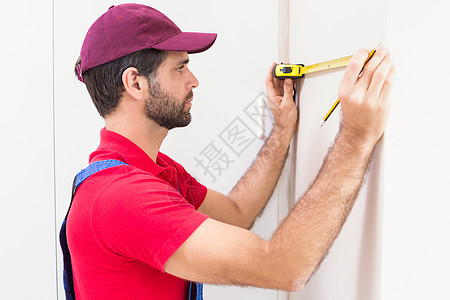 使用计量磁带的建筑工人男人防护承包商房子男性测量工作服工匠装修建筑图片