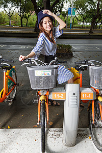 在台北市 由租车自行车的中国妇女驾驶环境女性女士女孩活力成人旅行城市运输闲暇背景图片