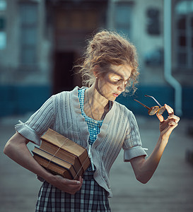 带书 眼镜和旧礼服的有趣女学生图片