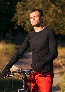 在日出时骑着山上自行车骑自行车的运动员 健康生活方式耀斑日落旅行下坡娱乐运动太阳骑术探索活动图片