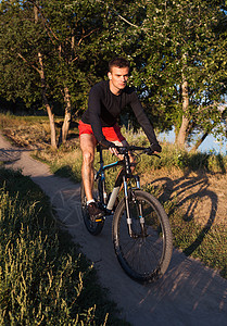 在日出时骑着山上自行车骑自行车的运动员 健康生活方式骑士运动娱乐太阳成人活动日落山地车下坡乐趣图片