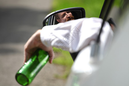 酒醉男人在车里喝着酒瓶酒驾驶人士车辆测试注意力警察瓶子运输汽车男性图片