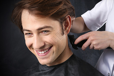 在发廊理发时 一个年轻白人男孩的肖像剃须沙龙修剪剃刀发型师美发黑色造型职业剪刀图片