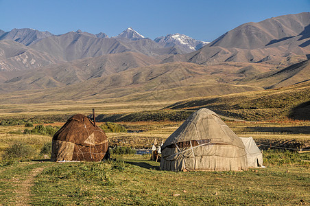 吉尔吉斯斯坦的Yurts住宅游牧民族部落山脉绿色草原丘陵风景图片