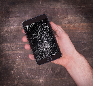 手握手机 屏幕被破碎碰撞电子细胞黑色修理玻璃白色展示电脑裂缝图片