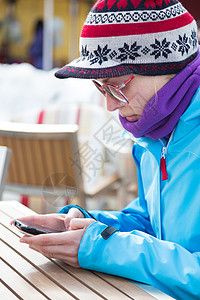 在滑雪度假村的女人 使用智能手机滑雪者活动喜悦技术女士青年运动闲暇滑雪模式图片