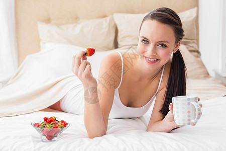 漂亮的黑发美女在床上吃早餐睡衣热饮家庭棕色咖啡闲暇家庭生活公寓健康饮食说谎图片