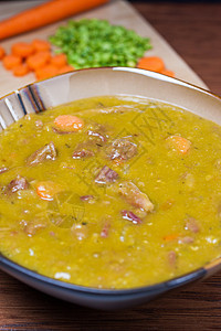Split Pea 汤碗木桌萝卜勺子食物火腿深色乡村猪肉桌子柜台背景图片