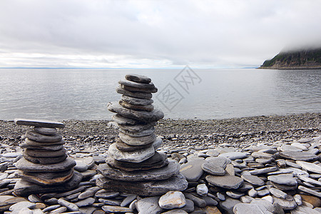 首湾背景的石头堆平衡冥想峡湾岩石天空艺术海滩海洋雕塑海岸图片