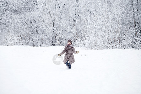 快乐的小女孩跑在雪上蒙着圆珠彩的背景下童年雪堆衣服女性夹克孩子乐趣女孩季节帽子图片