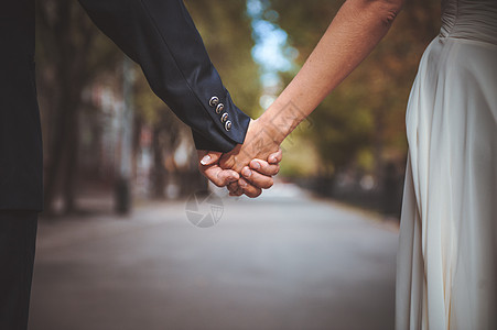 一对夫妇在公园里手牵手红色情感爱情故事玫瑰背景