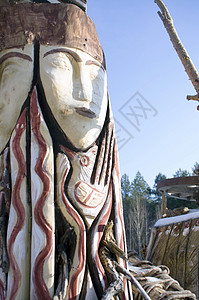 蓝色多云背景下的图腾木杆雕塑庆典工匠动物精神仪式面具宗教文化部落图片