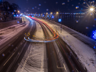夜晚的车灯在寒雪中的冰路上城市旅行大街交通照明风景运输爬坡房子景观图片