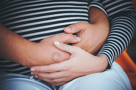 男人手握在前女的肚子上家庭水平婴儿夫妻腹部背景图片