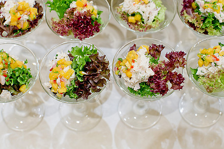 在一个透明的沙拉碗里吃开胃沙拉鲱鱼绿色立方体土豆红色洋葱蔬菜韭葱午餐膳食图片