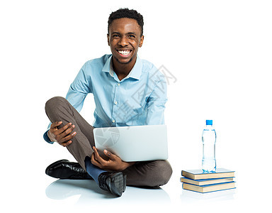 带着笔记本电脑坐着的非洲美国大学生快乐微笑教育白色黑色图书男性学校青年男人幸福图片