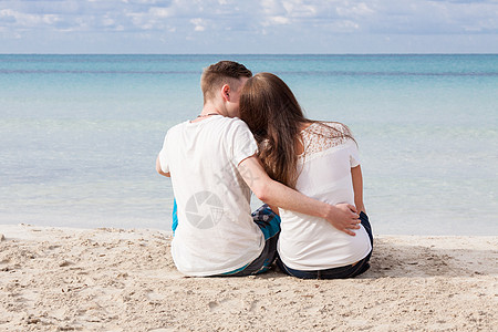 夏天坐在沙滩上的浪漫的年轻情侣女性幸福海岸男性女孩友谊喜悦蓝色海滩旅行图片