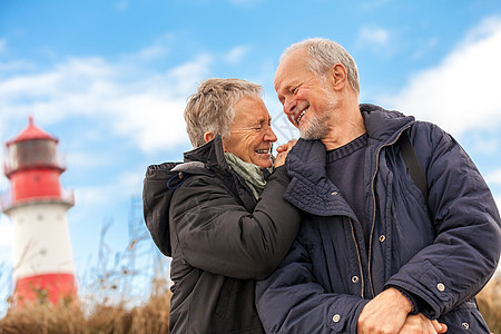 快乐的成熟情侣 放松黄海沙丘女性长者旅游旅行男人乐趣微笑蓝色天空夫妻图片