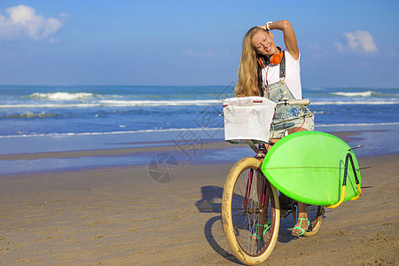 带冲浪板和自行车的年轻女孩冲浪木板金发海洋海滩青少年海浪运动冲浪者金发女郎图片