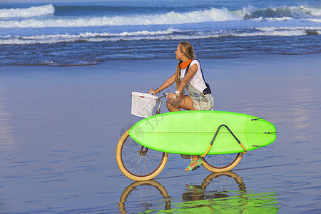 海滩上有冲浪板和自行车的小女孩金发女郎青少年金发女孩海洋冲浪比基尼微笑运动木板图片