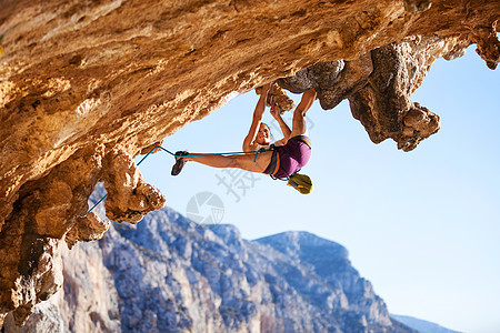 在悬崖上攀岩的年轻女性岩石女孩勇气危险登山者风险运动挑战绳索力量图片