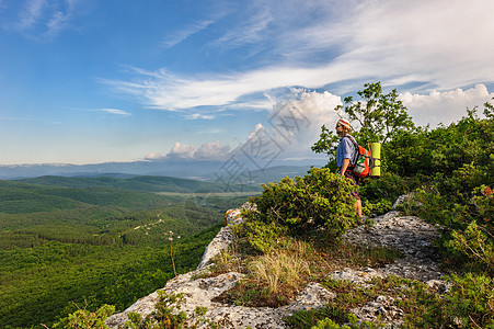 在日落的光芒中徒步旅行的人活动岩石男人上坡顶峰悬崖冒险峡谷闲暇背包图片