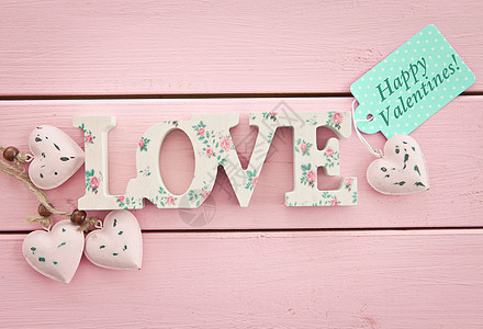 粉红木背景的爱礼品木头心形花卉标签刻字乡村粉色圆点图案图片