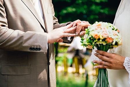 男人手把结婚戒指戴在新娘的手指上配偶金子生活珠宝指甲女性蜜月订婚妻子夫妻图片