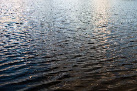 水面表面有波纹和太阳光反射镜池塘反射溪流水库光束洪水酒窝海浪太阳海洋图片