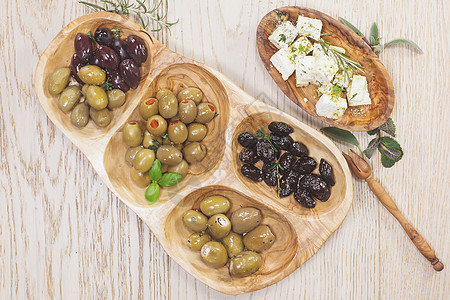 含乳酪的黑橄榄和绿橄榄小吃砧板木头用具服务餐厅沙拉水果烹饪桌子图片