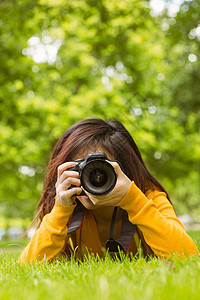 公园女摄影师女性单反说谎摄影相机棕色爱好绿地技术闲暇背景图片