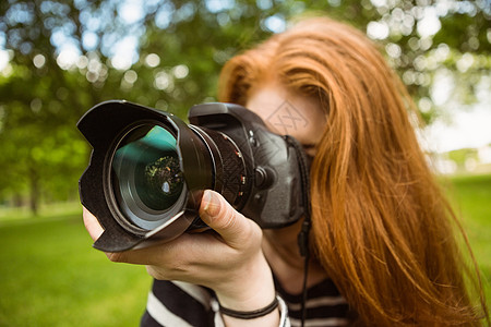 公园女摄影师爱好草地女性单反闲暇相机摄影绿地镜片技术背景图片