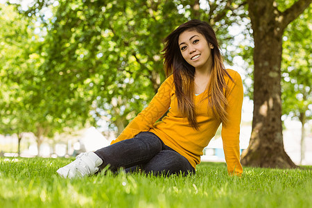 坐在公园草地上的美丽 放松的女人绿地微笑闲暇自由女性图片