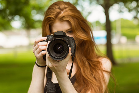 公园女摄影师单反爱好女性长发摄影相机技术绿地草地闲暇背景图片
