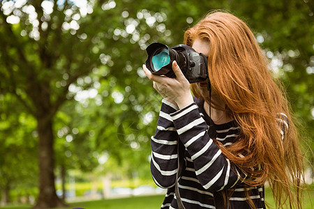 公园女摄影师单反女性技术长发草地爱好相机摄影绿地闲暇背景图片