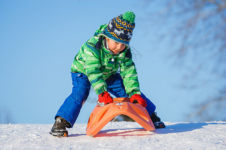 小男孩在冬季公园玩雪橇的乐趣季节男生喜悦雪花幸福快乐衣服孩子森林兄弟图片