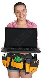 工具带显示妇女用空白屏幕打开笔记本电脑微笑工作室键盘女性建造装修工人出线盒牛仔裤衬衫图片