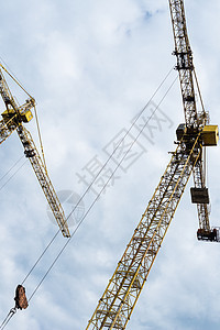 高塔起重机对着云天金属桅杆电缆配重框架建筑操作建筑学旋转工作图片
