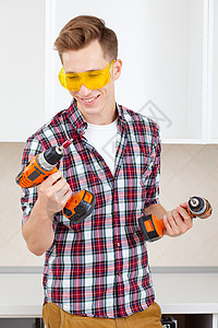 黄色安全眼镜上微笑的修理工选择工具图片