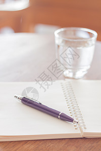 木制桌上的笔和空白螺旋笔笔工作喷泉教育皮革会议软垫笔记学习文档笔记本图片
