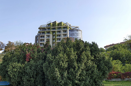 保加利亚多瑙河沿岸Ruse镇Ruse镇的河滨公园灌木大街绿色栅栏树木天空建筑公园红色长椅图片
