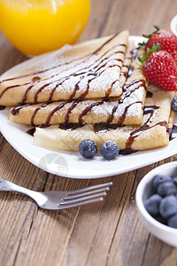 美味的甜甜法国煎饼 在盘子上和新鲜水果午餐食物饼子早餐金子奶油巧克力甜点蛋糕宏观图片