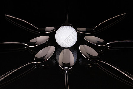 黑玻璃桌上的TESPOONS和白高尔夫球材料烹饪厨师勺子运动不锈钢早餐厨房餐厅派对图片