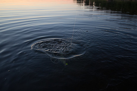 日落河渡海渔网和鱼棒图片