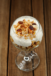玻璃中的格拉诺拉 木制背景的酸奶谷物水果饮食盘子甜点酒吧维生素空间早餐纹理图片