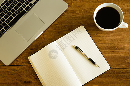 木制桌上的膝上型 笔记板和咖啡杯职场桌子饮料木头咖啡店会议笔记本咖啡键盘商业图片