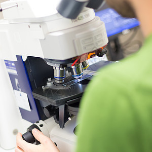 科学家在荧光显微镜上进行微扫瞄材料诊所开发商测试高科技基因物理样本研究员从业者图片
