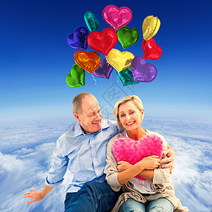 幸福的成熟夫妇和心枕的复合形象情怀软垫计算机微笑阳光女性高度气球顶峰衬衫图片