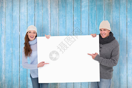 穿着保暖衣 张贴海报的情偶夫妇综合形象标语计算机手势亲密感男人微笑快乐羊毛女性木头图片