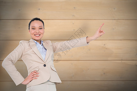 笑笑的亚洲女商务人士指着一副综合图像灰色计算机人士女性数字公司手势女士商业手指图片